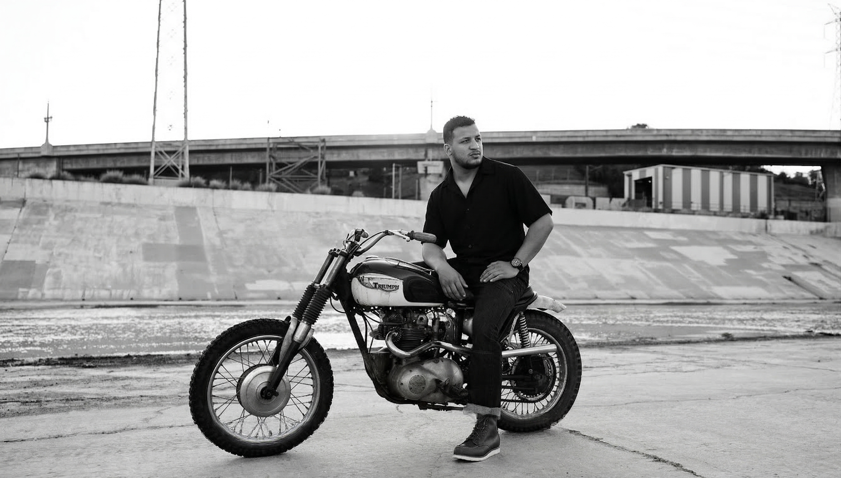 Man sitting on vintage motorcycle at golden hour sunset